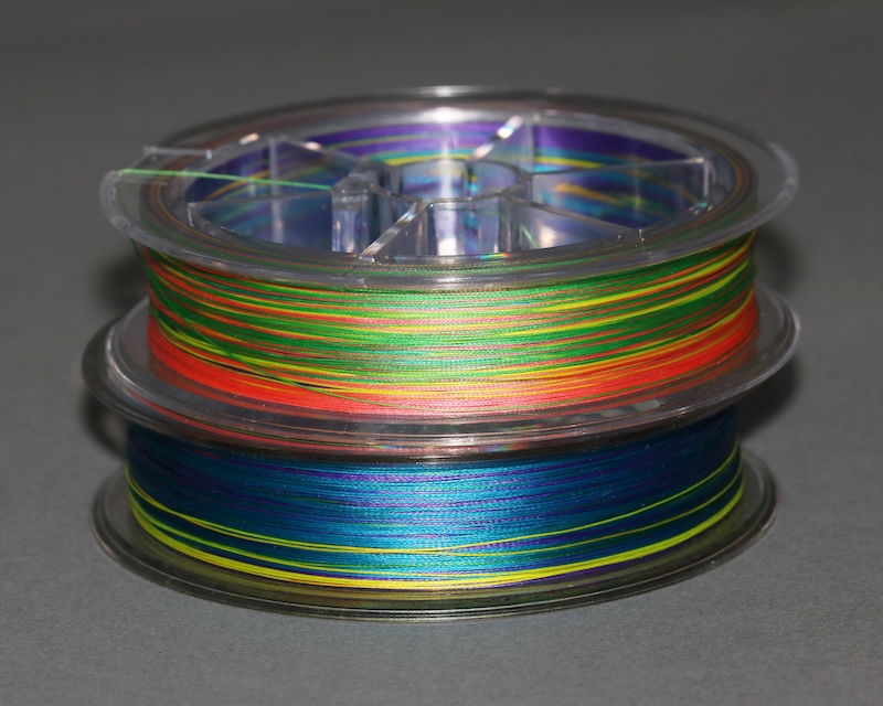 Two rolls of multi-colored braided fishing line stacked one on top of each other.