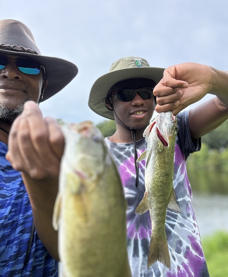 Perez and one of his students pose with the two large fish that they caught.