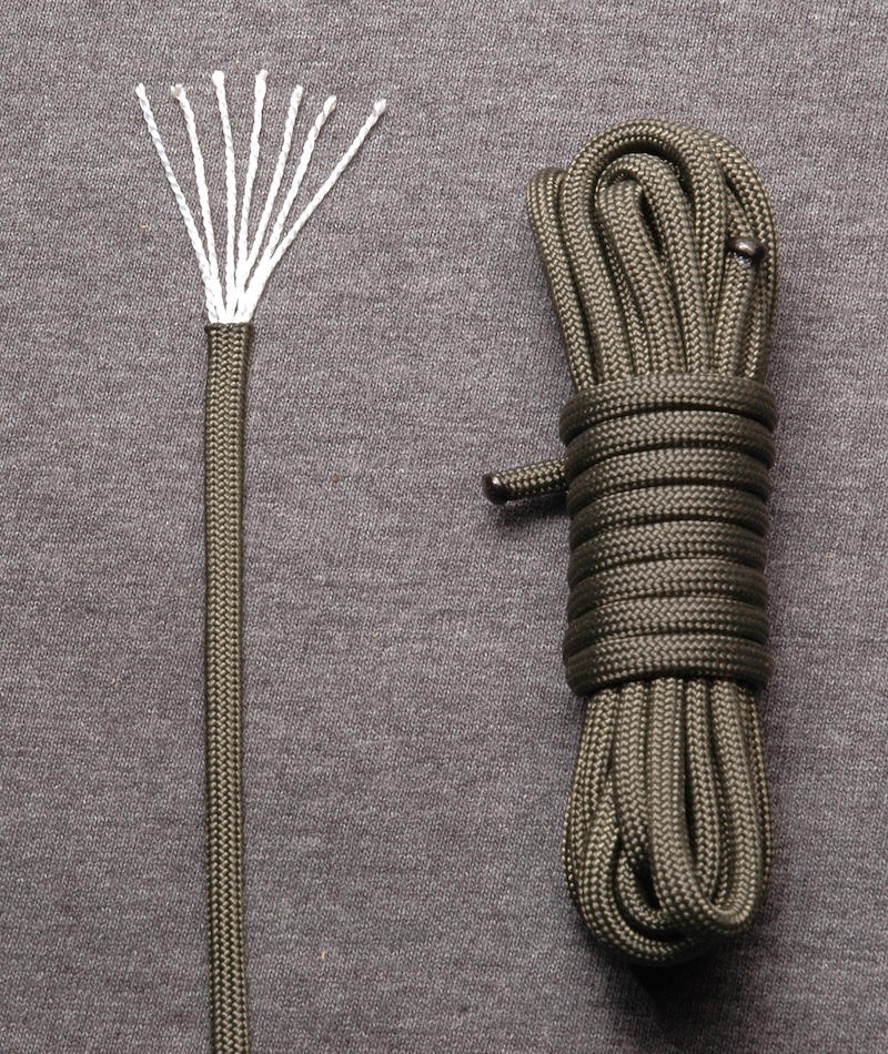 A close-up of a green braided rope frayed to show the inside fibers on the left and coiled in a tight skein on the right.